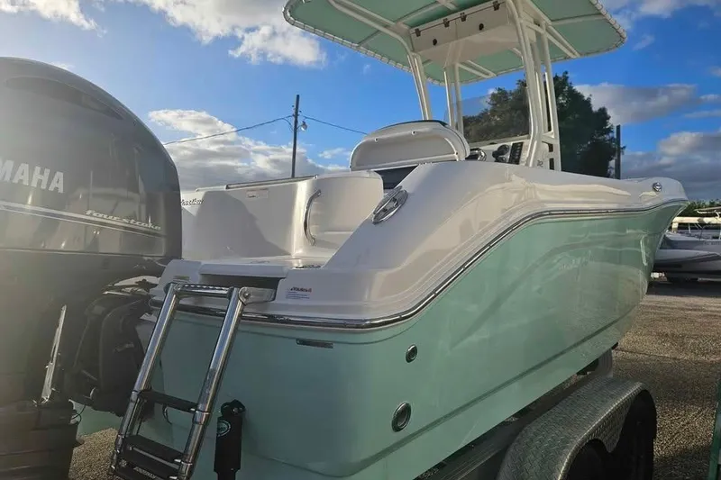 Slide: The Image of 2021 Robalo R202 Explorer boat with Yamaha engine, parked on trailer under blue sky. - 3