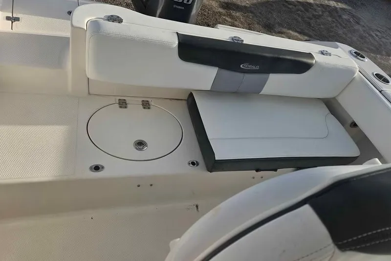 Slide: The Image of 2021 Robalo R202 Explorer boat interior with white seating and storage compartment. - 9