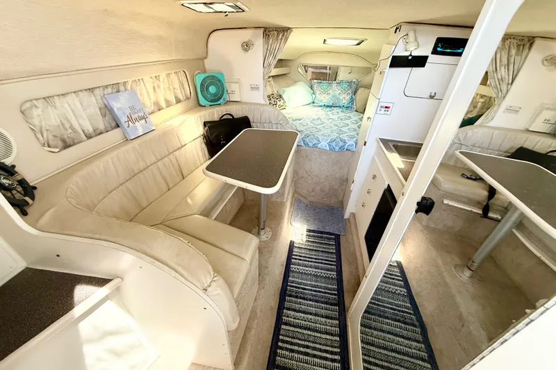 Slide: The Image of 1998 Rinker Fiesta Vee 280 cabin interior with bed, kitchenette, and fan. - 10