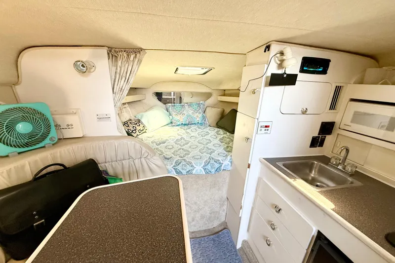 Slide: The Image of Compact kitchen in a 1998 Rinker Fiesta Vee 280 boat with sink, microwave, and stove. - 11