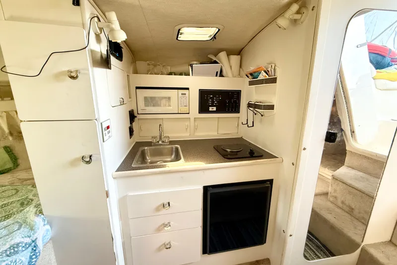 Slide: The Image of Interior of 1998 Rinker Fiesta Vee 280 boat with cozy seating and sleeping area. - 12