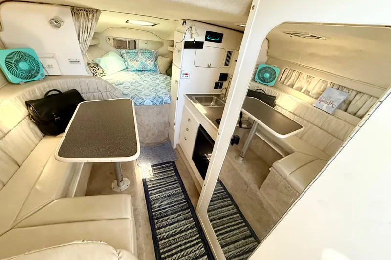 Slide: The Image of Interior of 1998 Rinker Fiesta Vee 280 boat, featuring cozy seating and storage. - 13