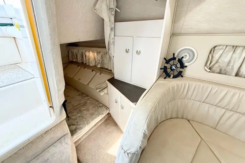 Slide: The Image of Interior cabin of 1998 Rinker Fiesta Vee 280 with storage compartments and patterned upholstery. - 14