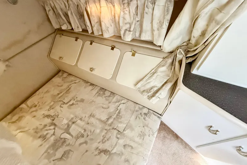 Slide: The Image of Interior cabin of 1998 Rinker Fiesta Vee 280 boat, featuring a cozy sleeping area. - 15