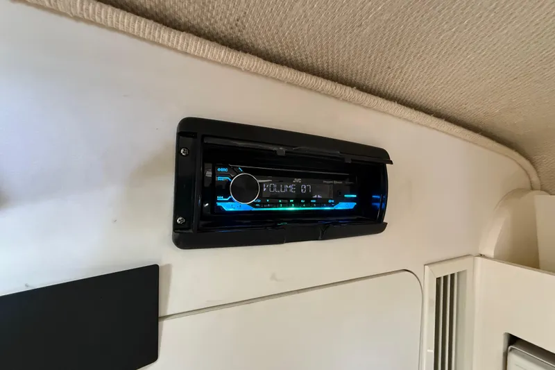 Slide: The Image of Cozy cabin interior of 1998 Rinker Fiesta Vee 280 with bed, TV, and floral decor. - 17