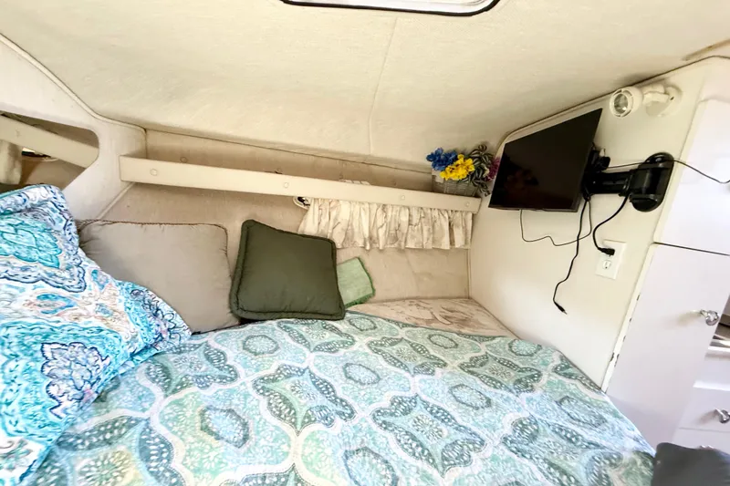 Slide: The Image of Interior of a 1998 Rinker Fiesta Vee 280 boat with cozy seating and kitchenette. - 18