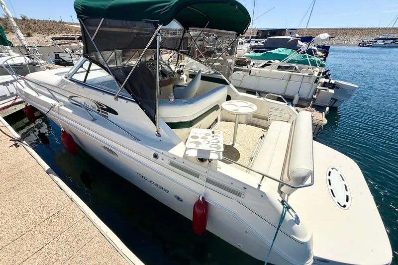 Slide: The Image of 1998 Rinker Fiesta Vee 280 boat docked at marina with canopy and seating area. - 2