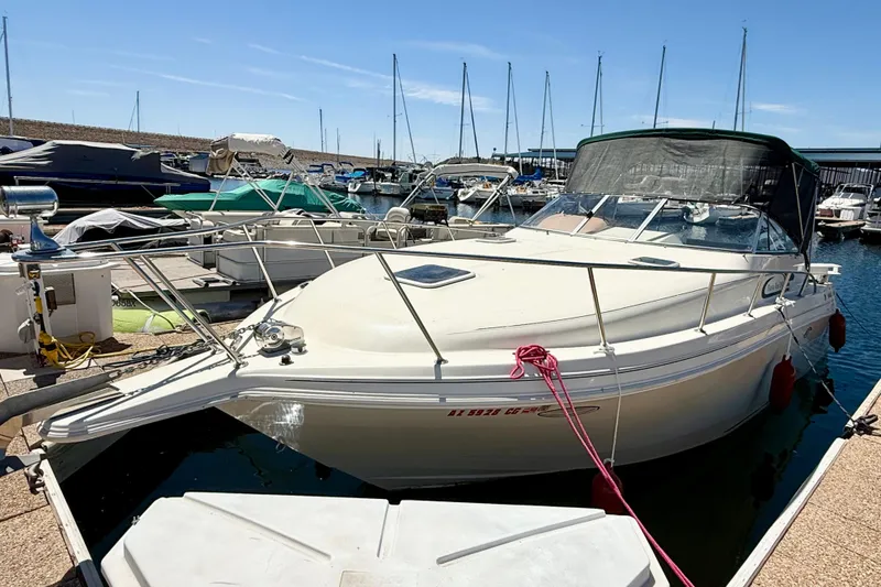 Slide: The Image of 1998 Rinker Fiesta Vee 280 boat docked at marina, featuring spacious seating and canopy. - 5