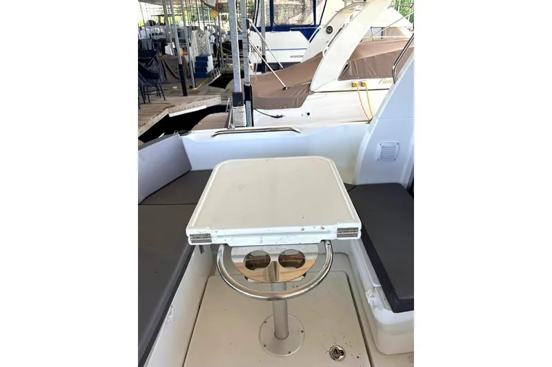 Slide: The Image of 2023 Beneteau Antares 7 boat interior with table and seating in a marina setting. - 17