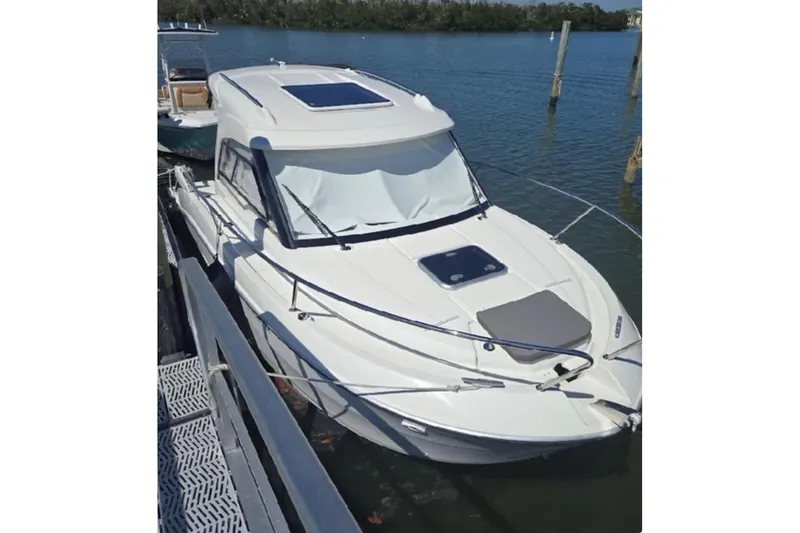 Slide: The Image of 2023 Beneteau Antares 7 boat docked on calm water, showcasing sleek design. - 2