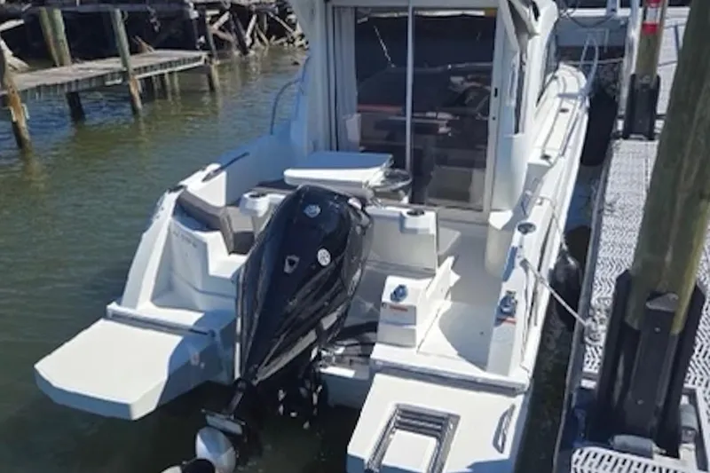 Slide: The Image of 2023 Beneteau Antares 7 boat docked, featuring a powerful outboard motor. - 4