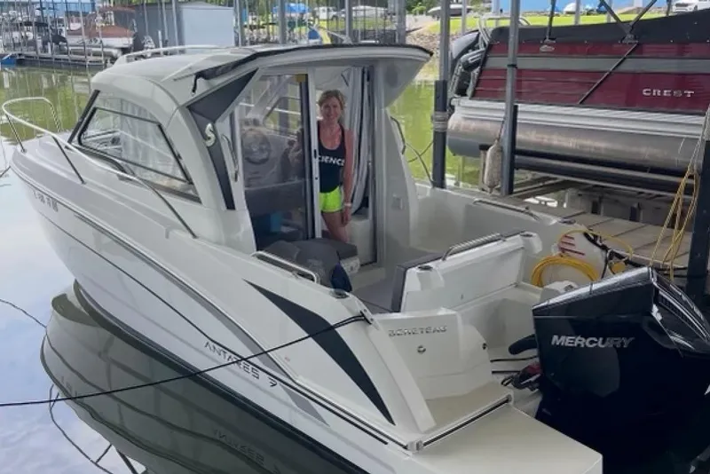 Slide: The Image of 2023 Beneteau Antares 7 boat docked, featuring sleek design and Mercury outboard engine. - 5