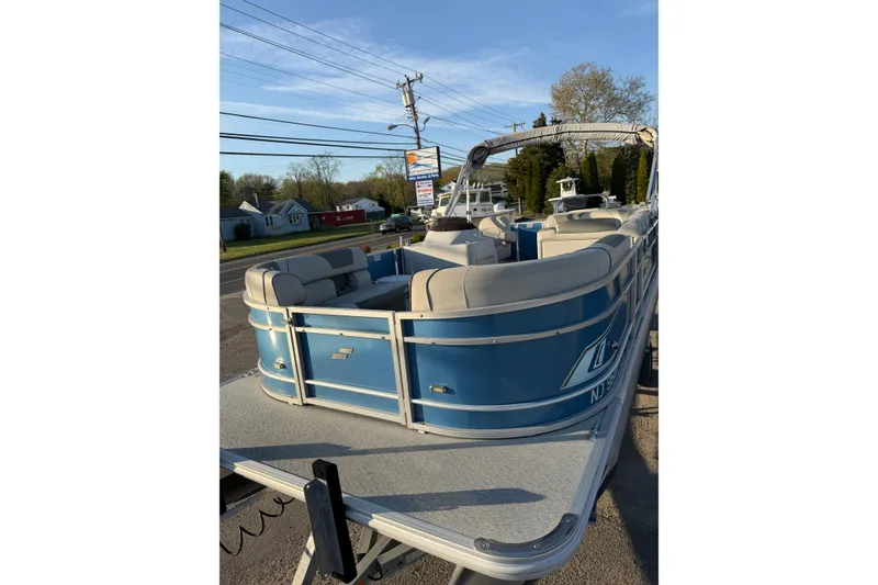 Slide: The Image of 2018 Starcraft EX 22 C SG pontoon boat with blue exterior and beige seating. - 10