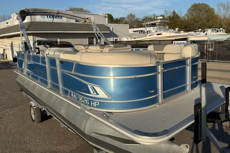 Slide: The Image of 2018 Starcraft EX 22 C SG pontoon boat with blue exterior on a trailer. - 11