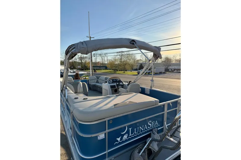 Slide: The Image of 2018 Starcraft EX 22 C SG pontoon boat with blue exterior and spacious seating. - 12