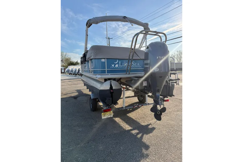 Slide: The Image of 2018 Starcraft EX 22 C SG pontoon boat with Yamaha 150 engine, parked outdoors. - 13
