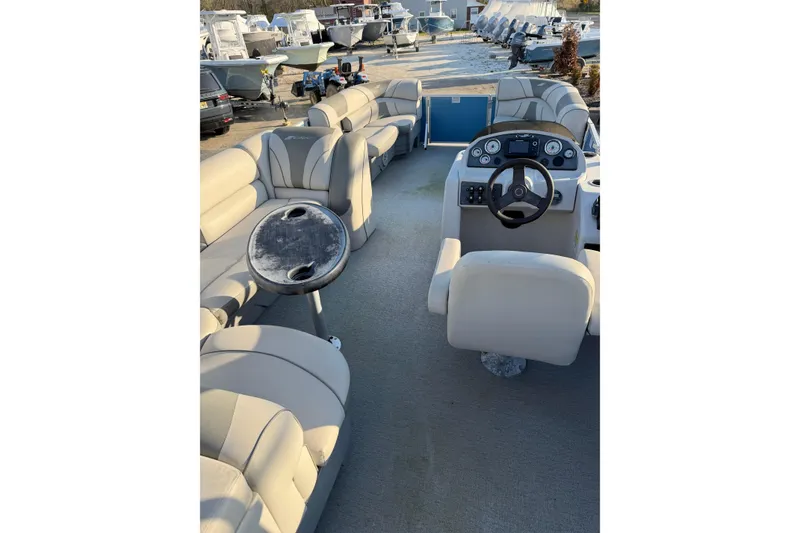 Slide: The Image of 2018 Starcraft EX 22 C SG pontoon boat interior with beige seating and steering console. - 16