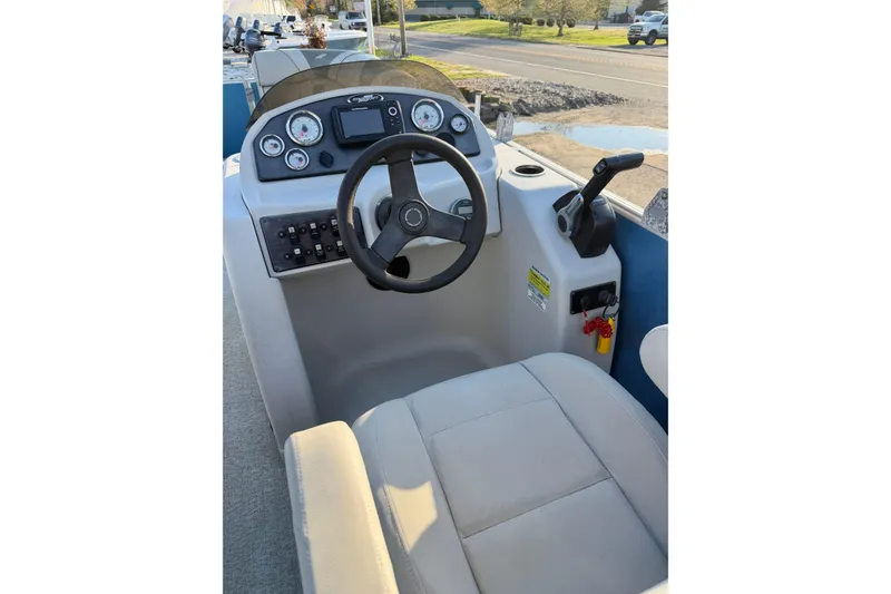 Slide: The Image of 2018 Starcraft EX 22 C SG boat cockpit with steering wheel and control panel. - 18