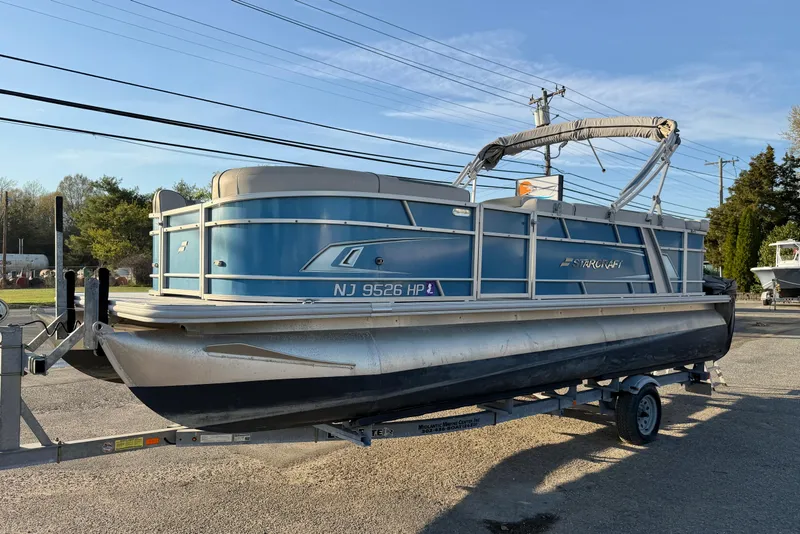 Slide: The Image of 2018 Starcraft EX 22 C SG pontoon boat on trailer, parked outdoors. - 8