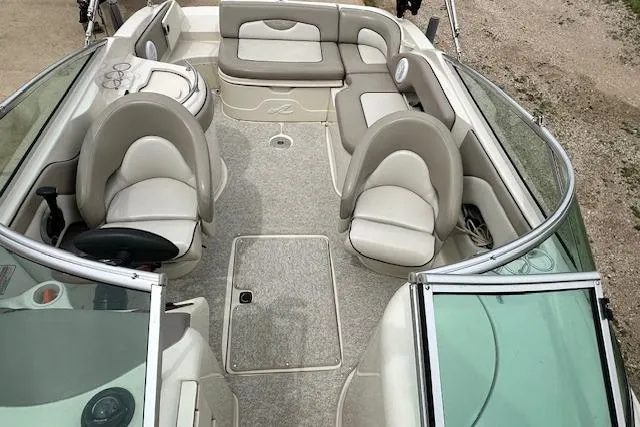 Slide: The Image of 2004 Sea Ray 270 Sundeck interior with beige seating and open deck layout. - 13