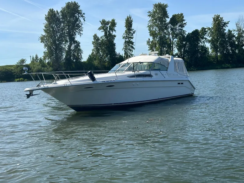 The Image of 1993 Sea Ray Sundancer 370 on calm water with trees in background. - 1