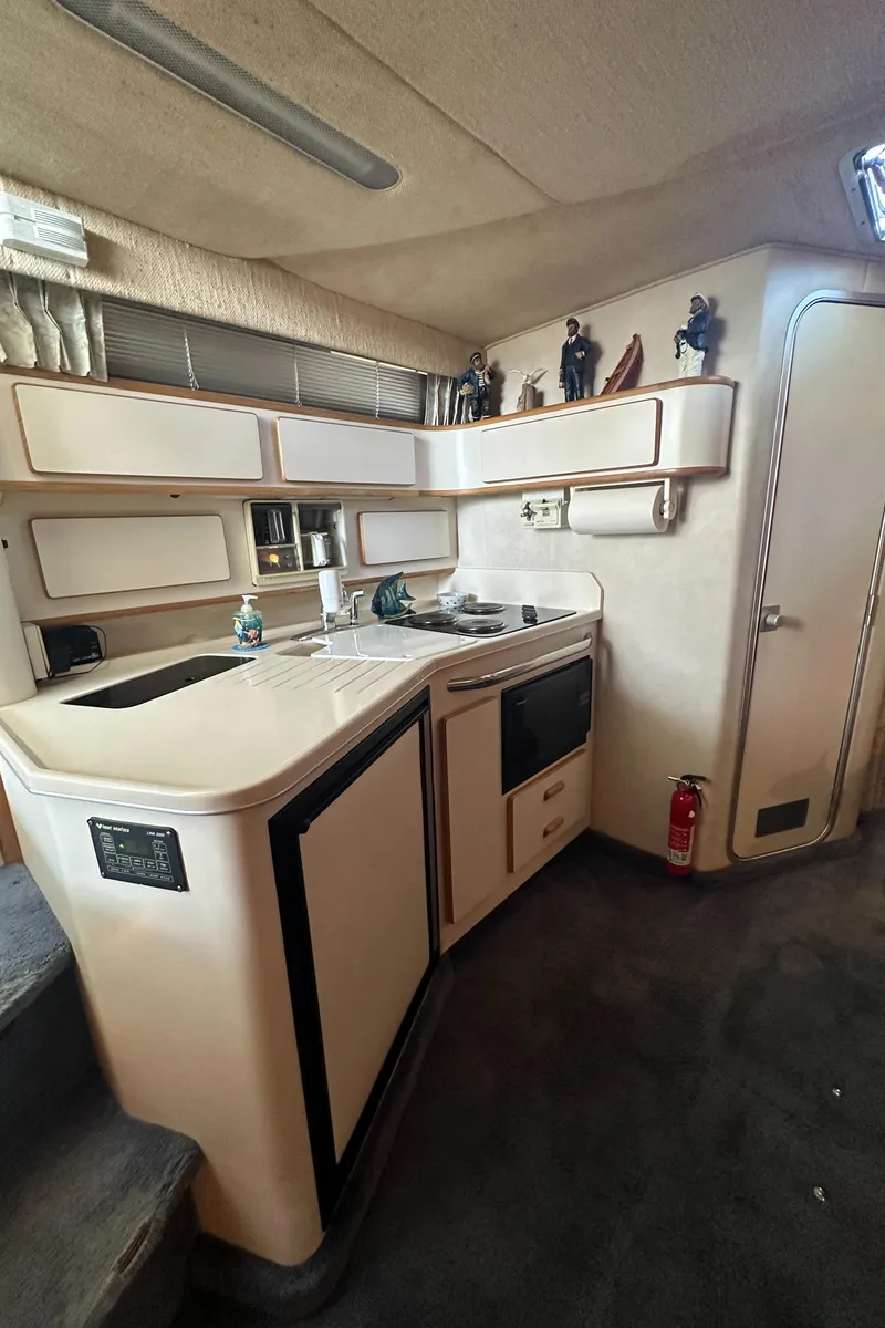 Slide: The Image of Interior of 1993 Sea Ray Sundancer 370 yacht featuring a compact kitchen. - 24