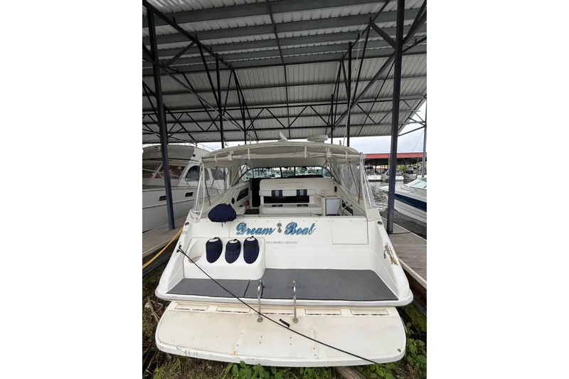 Slide: The Image of 1993 Sea Ray Sundancer 370 docked under a metal canopy, rear view. - 50