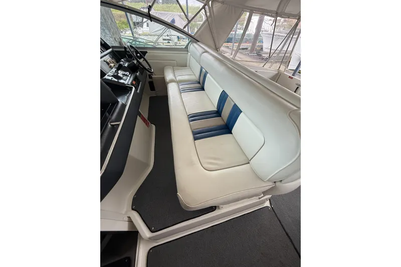Slide: The Image of 1993 Sea Ray Sundancer 370 interior with white and blue seating, helm, and controls. - 53
