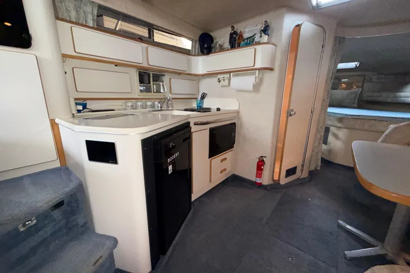 Slide: The Image of Interior of 1993 Sea Ray Sundancer 370 yacht featuring kitchen area with appliances and seating. - 57