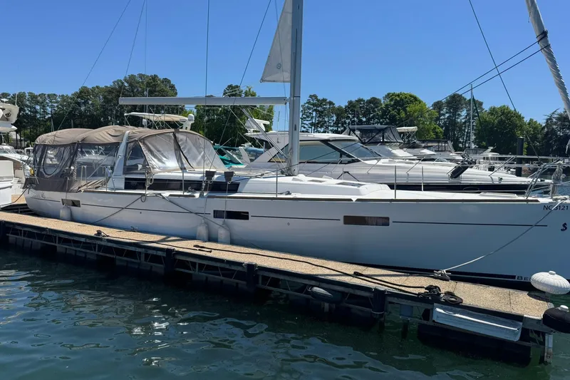 The Image of 2014 Beneteau Oceanis 45 sailboat docked at marina under clear blue sky. - 0