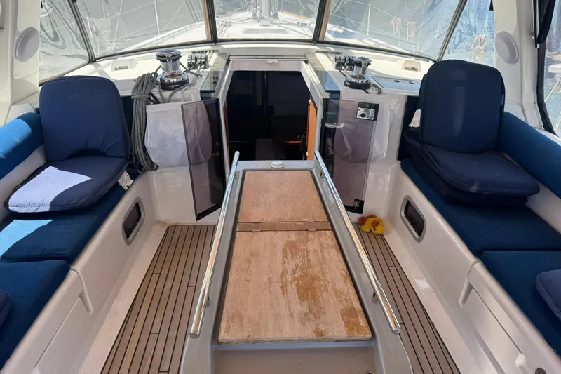 Slide: The Image of Cockpit of 2014 Beneteau Oceanis 45 sailboat with blue cushions and wooden table. - 10