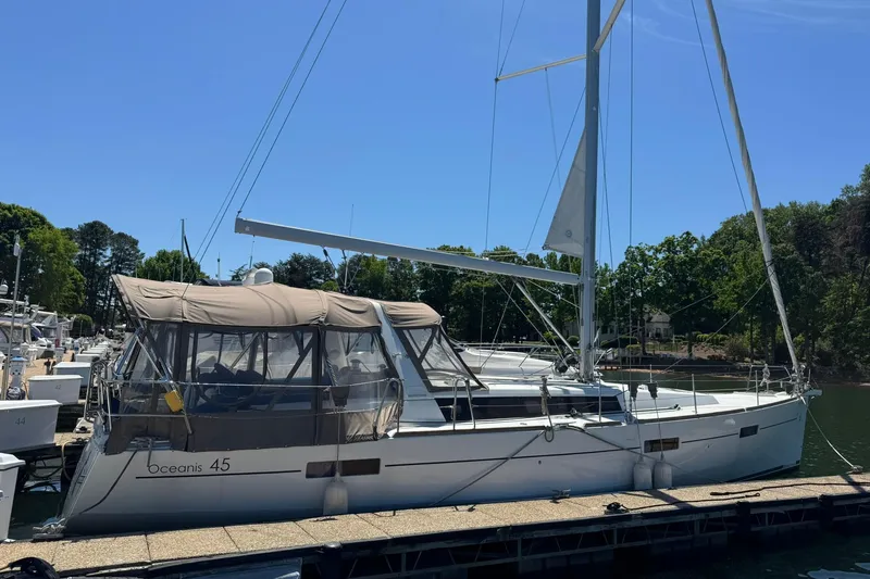 Slide: The Image of 2014 Beneteau Oceanis 45 sailboat docked at a marina under clear blue skies. - 2