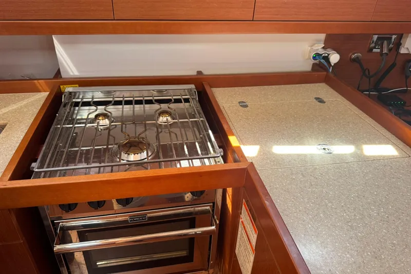 Slide: The Image of Galley kitchen in 2014 Beneteau Oceanis 45 yacht with stove, sink, and wooden cabinetry. - 29