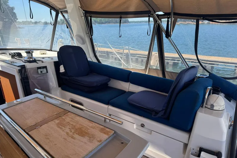 Slide: The Image of Interior view of 2014 Beneteau Oceanis 45 yacht with blue seating and wooden table. - 9