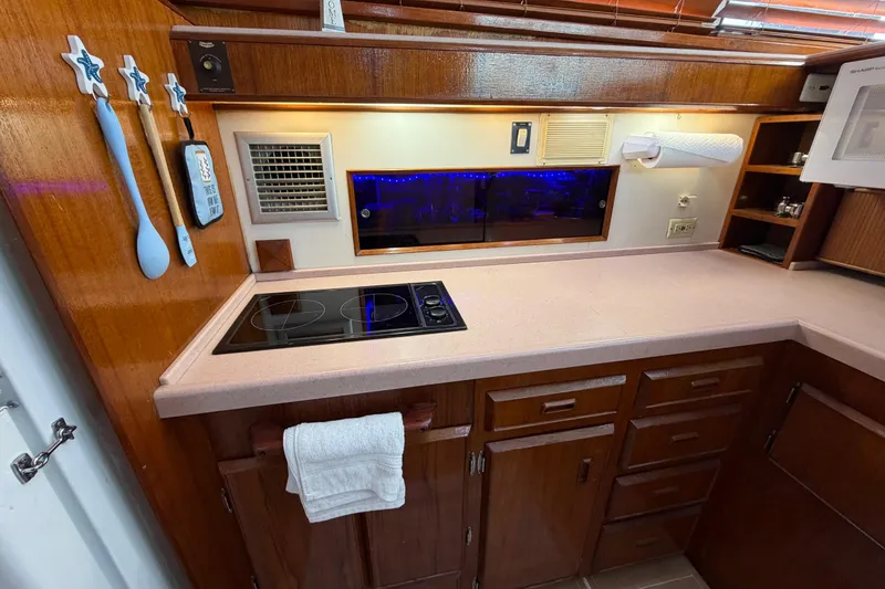 Slide: The Image of 1986 Bertram 46 Convertible yacht kitchen with wooden cabinets and modern appliances. - 17