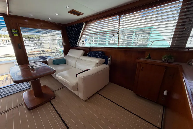 Slide: The Image of Interior of 1986 Bertram 46 Convertible yacht with white sofa and wooden table. - 18
