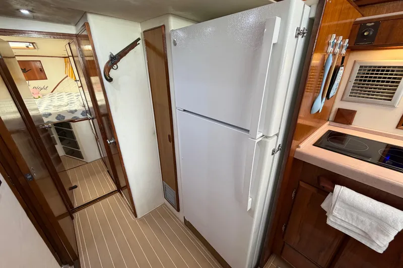 Slide: The Image of Interior of a 1986 Bertram 46 Convertible yacht with kitchen and bedroom view. - 22