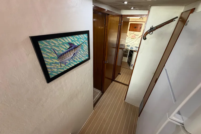 Slide: The Image of Interior hallway of 1986 Bertram 46 Convertible with nautical artwork and wooden accents. - 23