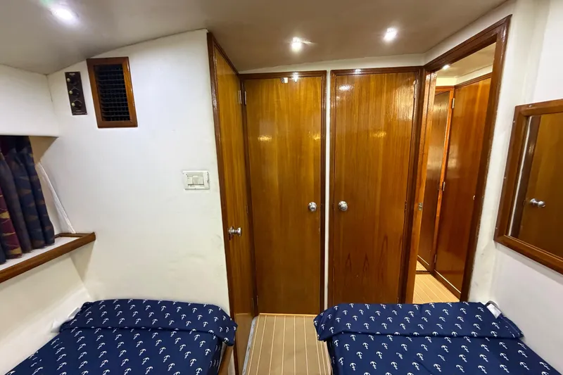 Slide: The Image of Interior cabin of 1986 Bertram 46 Convertible yacht with twin beds and wooden doors. - 27