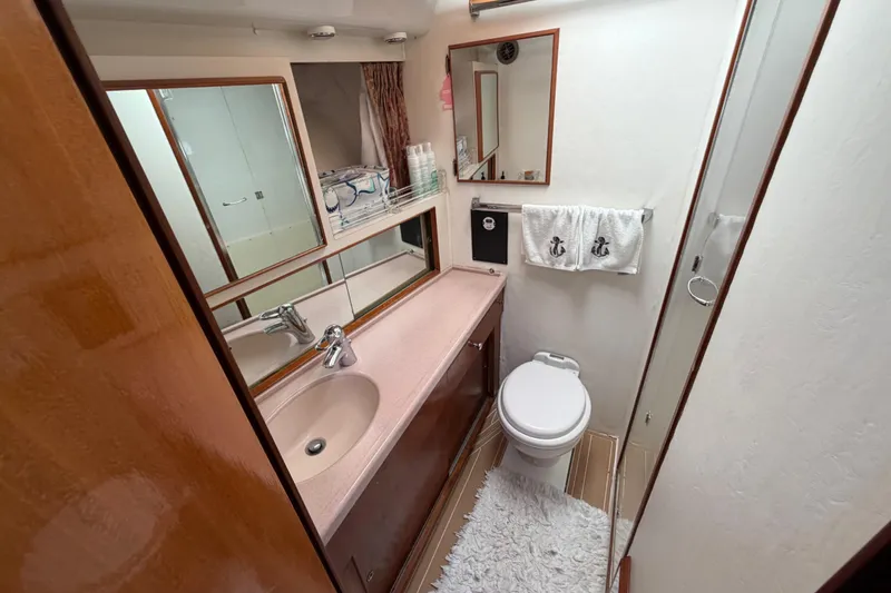 Slide: The Image of Bathroom interior of 1986 Bertram 46 Convertible yacht, featuring sink, toilet, and shower. - 28