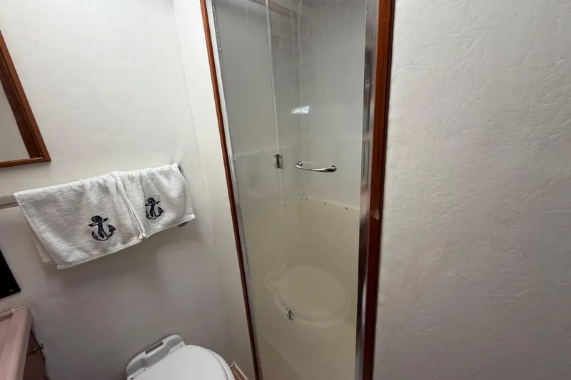 Slide: The Image of Bathroom interior of 1986 Bertram 46 Convertible yacht with shower and anchor-themed towels. - 33