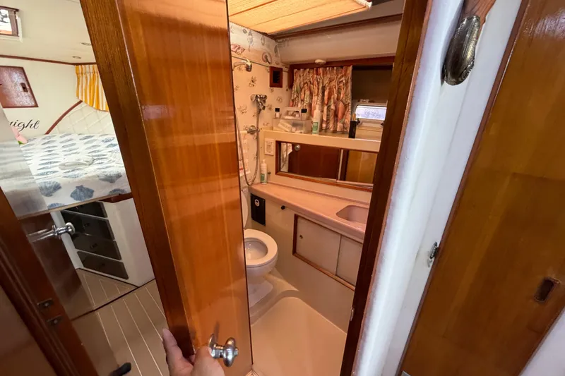 Slide: The Image of 1986 Bertram 46 Convertible yacht bathroom with wooden door, sink, and toilet. - 34
