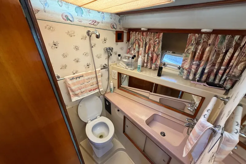 Slide: The Image of Bathroom interior of a 1986 Bertram 46 Convertible yacht with floral decor. - 36