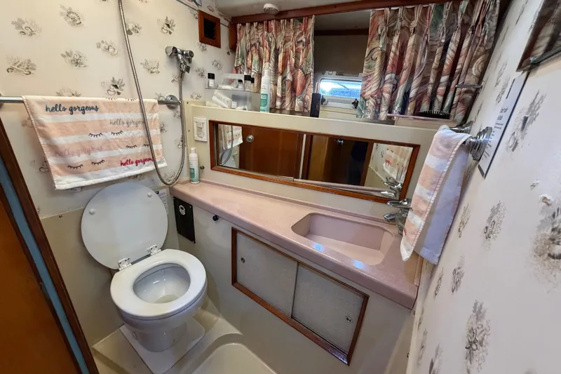Slide: The Image of Bathroom interior of 1986 Bertram 46 Convertible yacht with floral decor and pink countertop. - 37