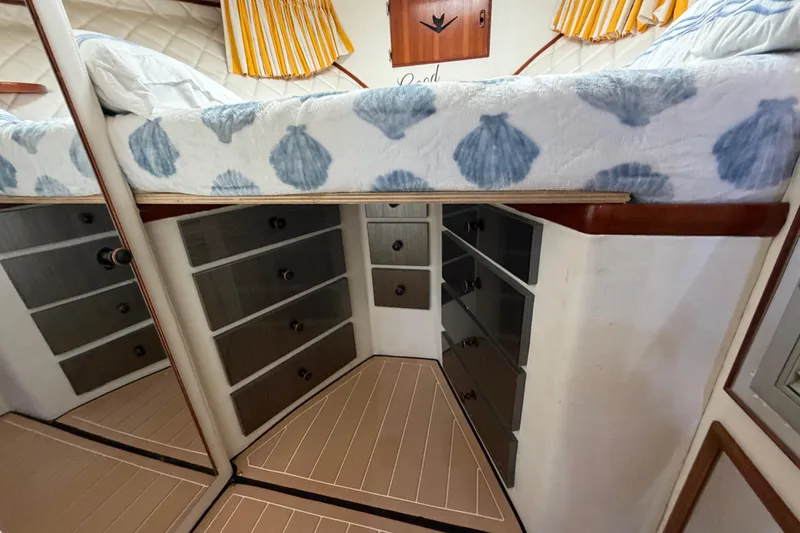 Slide: The Image of Interior of 1986 Bertram 46 Convertible with bed, drawers, and striped curtains. - 39
