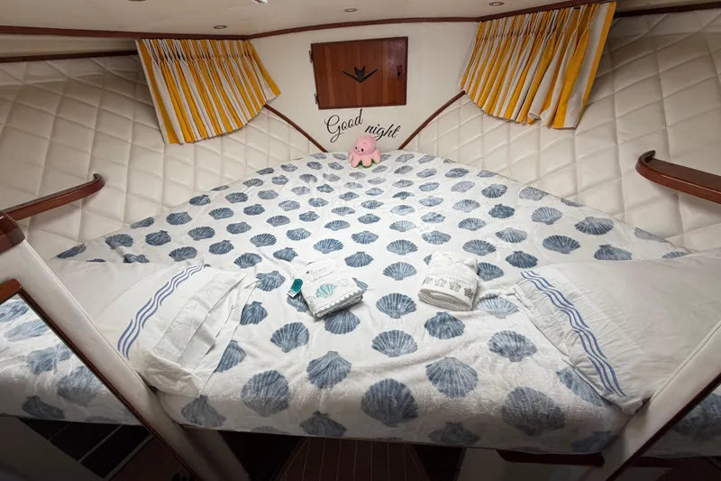 Slide: The Image of Cozy cabin interior of 1986 Bertram 46 Convertible with seashell-patterned bedding. - 40
