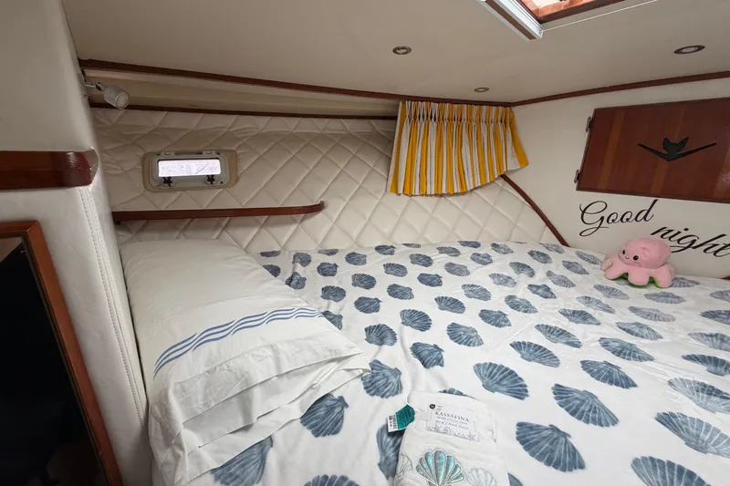 Slide: The Image of Cozy cabin interior of 1986 Bertram 46 Convertible with nautical-themed bedding and decor. - 41