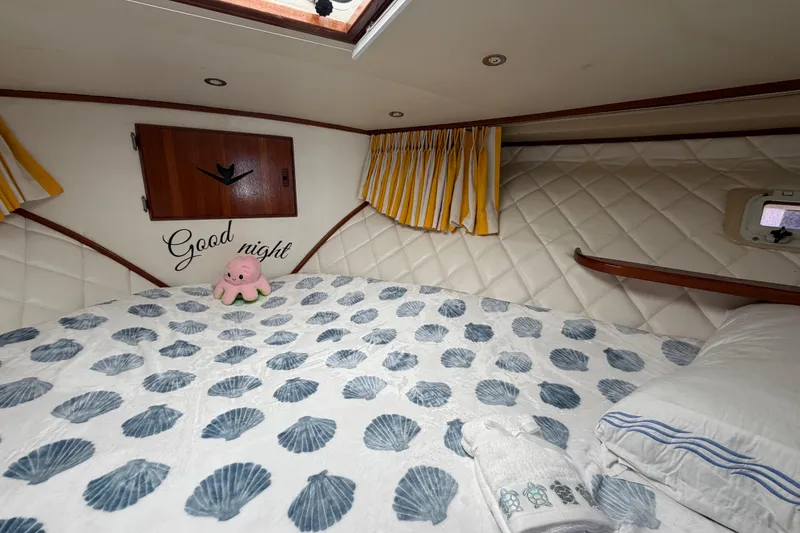 Slide: The Image of Cozy cabin interior of 1986 Bertram 46 Convertible with nautical decor and plush bedding. - 42