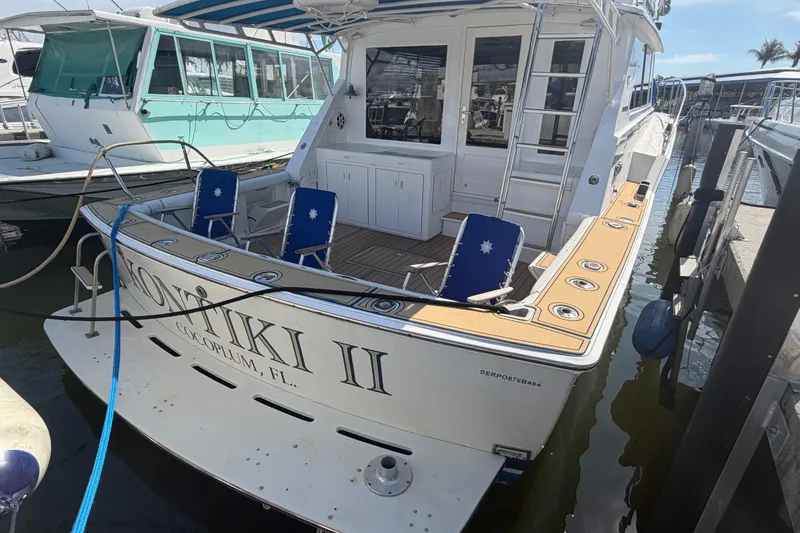 Slide: The Image of 1986 Bertram 46 Convertible yacht docked, featuring spacious deck and seating area. - 45