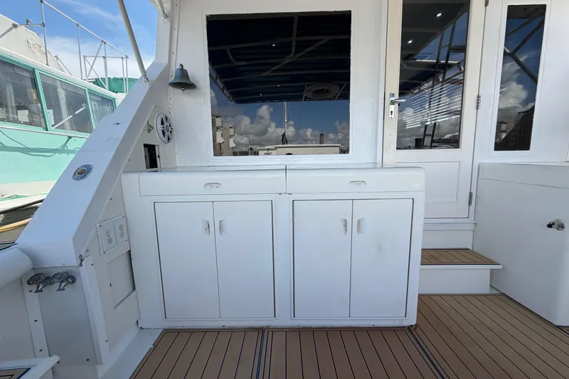 Slide: The Image of 1986 Bertram 46 Convertible yacht deck with white cabinetry and wooden flooring. - 50